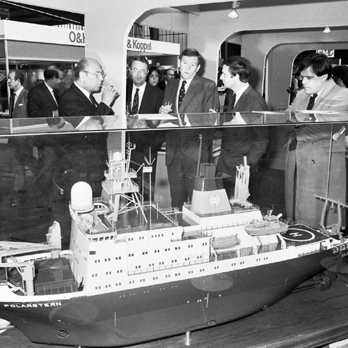 A black-and-white photograph of an exhibition piece at a trade fair, featuring a ship model that may be a representation of a real ship