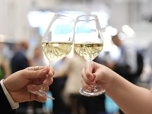 Toasting wine glasses Close-up of two wine glasses being held in a man's and a woman's hand. They're clinking the glasses.