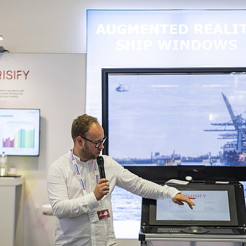 Nahaufnahme eines Redners während einer Präsentation über Augmented Reality in der Schifffahrt.