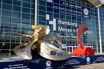 „Außenbereich der Hamburg Messe mit SMM‑Skulpturen vor dem Messe‑Eingang.“