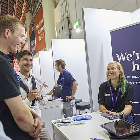 Ausstellende unterhalten sich mit Besuchenden. 