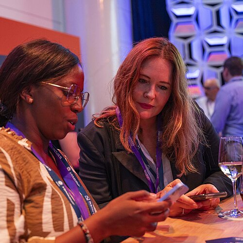 Zwei Frauen unterhalten sich bei einem Getränk im Career Forum. 