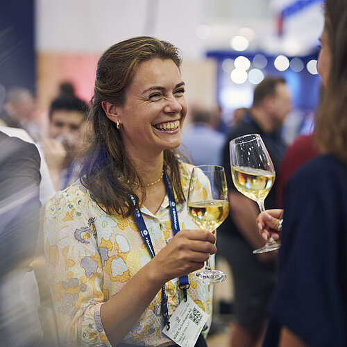 Zwei Frauen unterhalten sich und trinken Sekt.